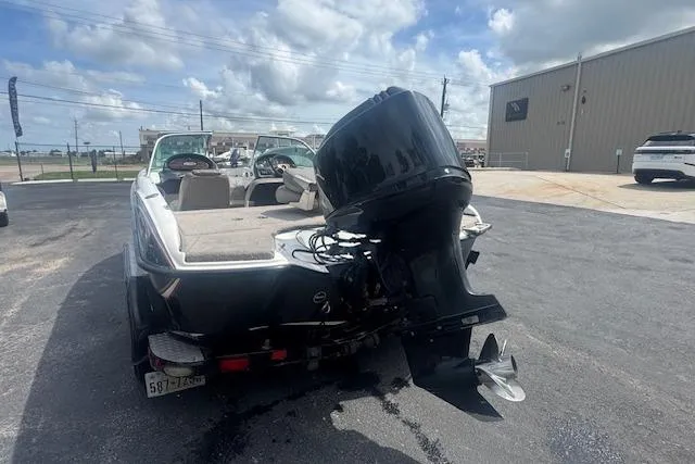 Slide: The Image of 2002 Triton 190-FS boat with outboard motor, parked on asphalt near industrial building. - 4