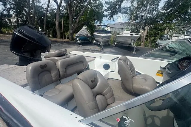 Slide: The Image of 2002 Triton 190-FS boat interior with leather seats, parked among other boats. - 7
