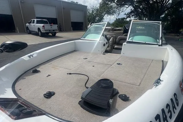 Slide: The Image of 2002 Triton 190-FS boat with open deck, parked near a garage. - 9
