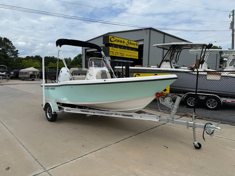 Slide: The Image of 2025 Key West 179 FS boat on trailer at dealership, outdoor display. - 2