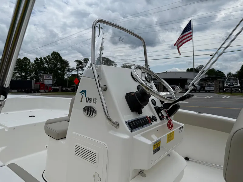 Slide: The Image of 2025 Key West 179 FS boat console with steering wheel, American flag in background. - 21