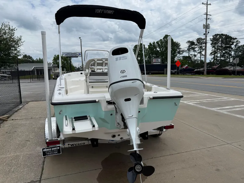 Slide: The Image of 2025 Key West 179 FS boat with outboard motor, parked on a street. - 9