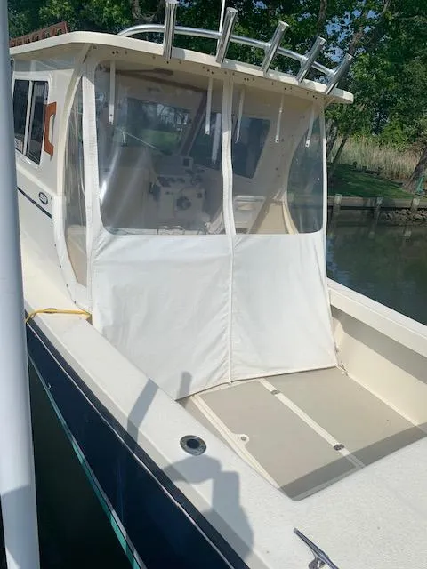 Slide: The Image of 2011 Eastern 24 Explorer boat with enclosed cabin, docked near greenery. - 4