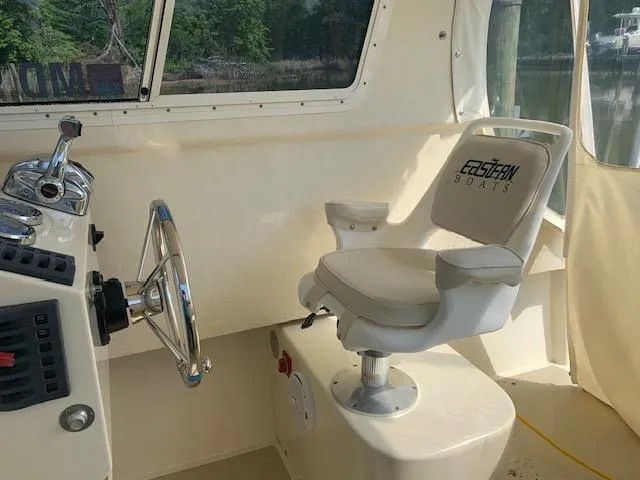Slide: The Image of Interior of a 2011 Eastern 24 Explorer boat with steering wheel and captain's chair. - 6