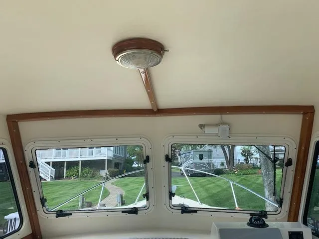 Slide: The Image of Interior view of 2011 Eastern 24 Explorer boat with windows and ceiling light. - 9