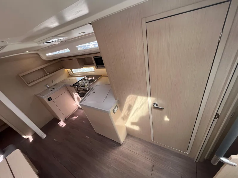 Slide: The Image of 2023 Beneteau Oceanis 40.1 interior with modern kitchen and wood finish. - 13