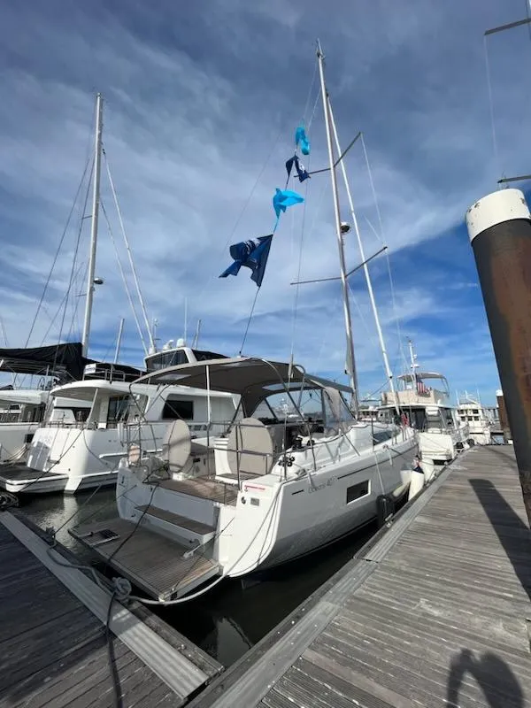 Slide: The Image of 2023 Beneteau Oceanis 40.1 sailboat docked at marina under clear blue sky. - 3