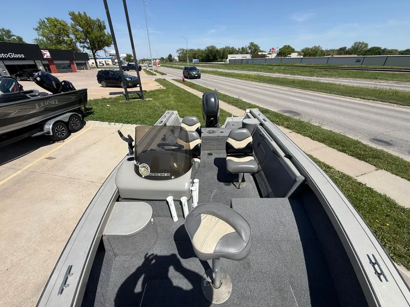 Slide: The Image of 2003 Tracker Targa 18 SC boat with seating, parked near a road on a sunny day. - 5