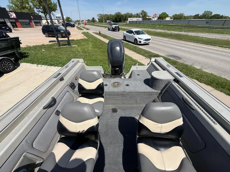 Slide: The Image of 2003 Tracker Targa 18 SC boat interior with seating and motor, parked near a road. - 7