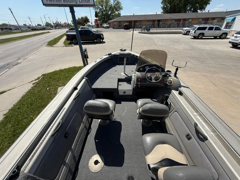 Slide: The Image of 2003 Tracker Targa 18 SC boat interior with seating and steering console, parked on a street. - 8