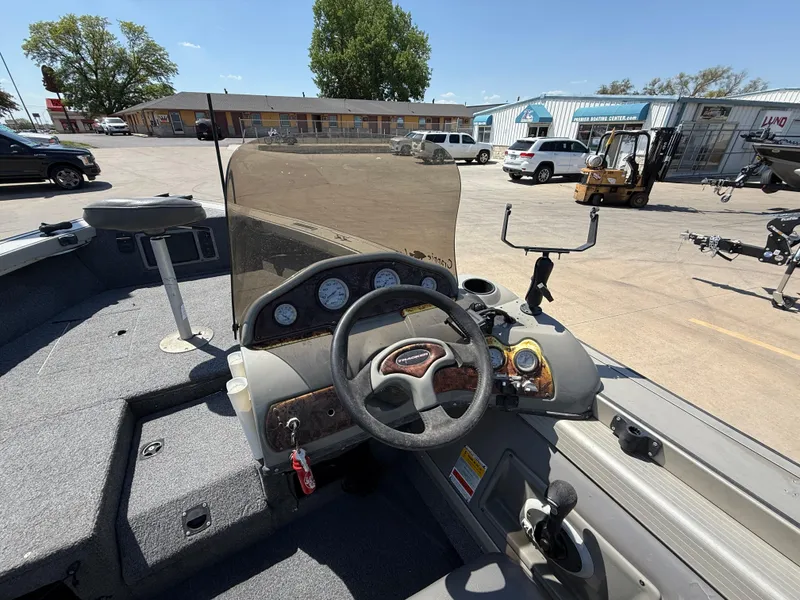 Slide: The Image of 2003 Tracker Targa 18 SC boat dashboard with steering wheel and gauges in a parking lot. - 9