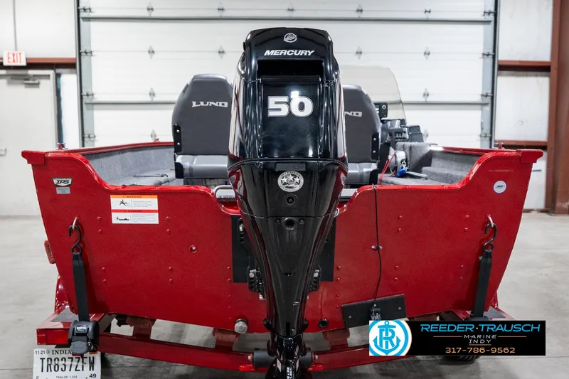 Slide: The Image of 2021 Lund 1650 ANG SS boat with Mercury 56 engine, red exterior, in a garage setting. - 7