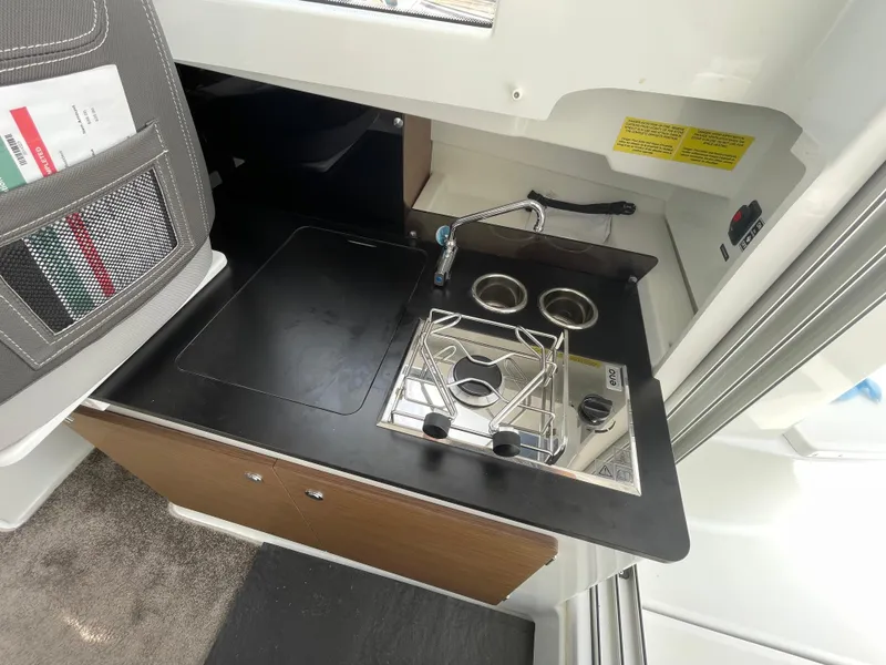 Slide: The Image of Compact fridge in 2022 Jeanneau NC 695 Series 2 boat interior, open with drink inside. - 11