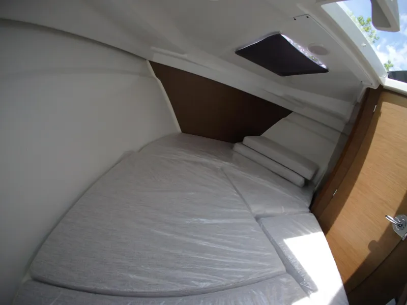 Slide: The Image of 2022 Jeanneau NC 695 Series 2 cabin interior with cushioned seating and wooden accents. - 15