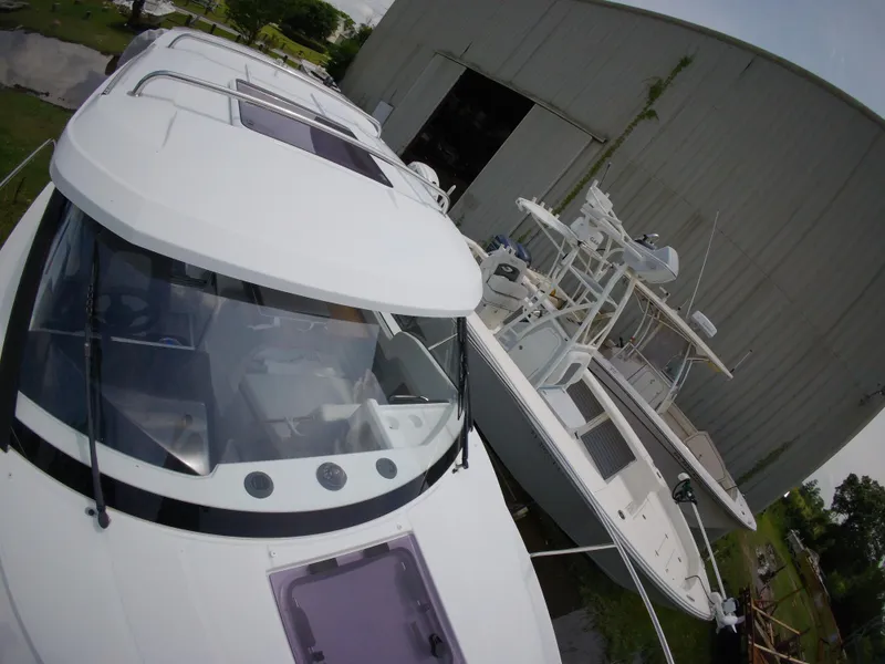 Slide: The Image of 2022 Jeanneau NC 695 Series 2 boat in storage yard, surrounded by other vessels. - 20