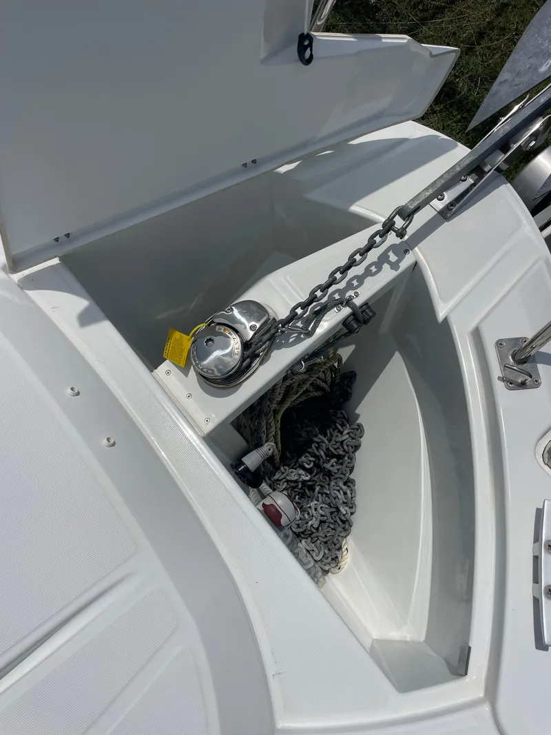 Slide: The Image of 2022 Jeanneau NC 695 Series 2 boat on land, surrounded by other vessels and equipment. - 22