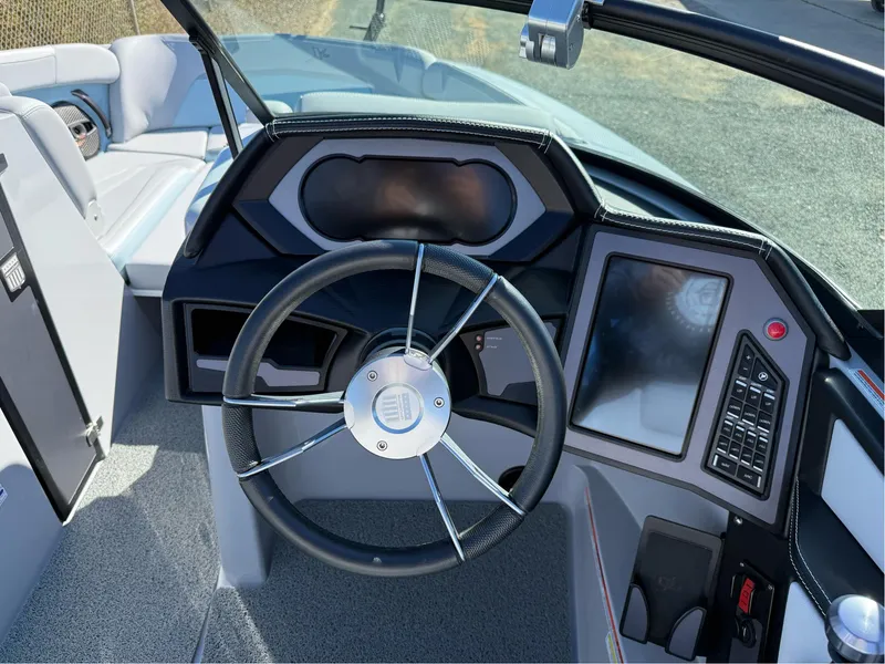 Slide: The Image of 2024 MasterCraft XStar S boat dashboard with steering wheel and touchscreen controls. - 14