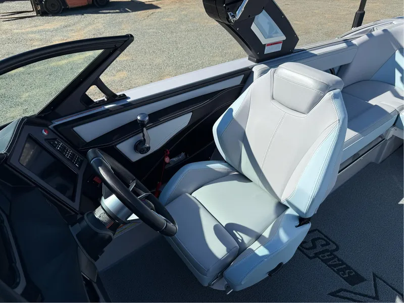 Slide: The Image of 2024 MasterCraft XStar S boat interior with sleek steering and modern seating. - 16