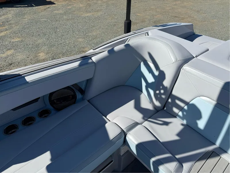 Slide: The Image of 2024 MasterCraft XStar S boat interior with light gray seating and speaker system. - 20