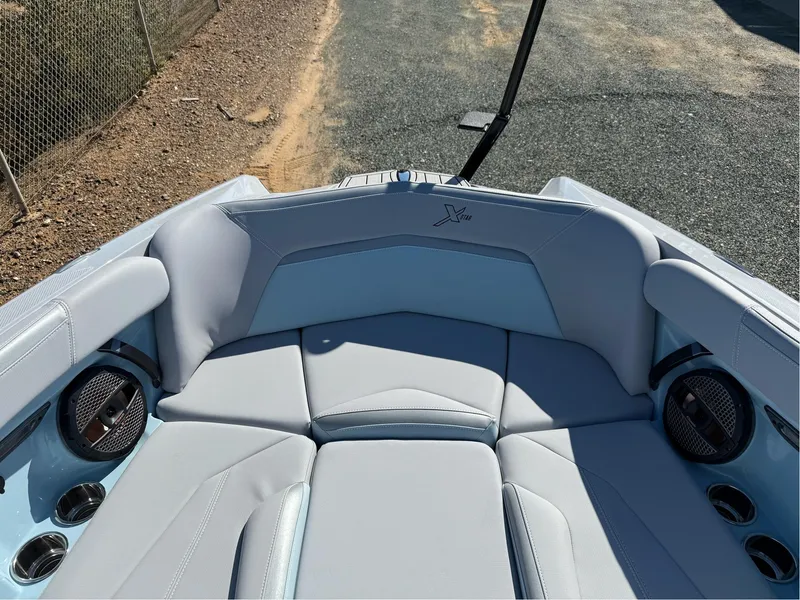 Slide: The Image of 2024 MasterCraft XStar S boat interior with plush seating and cup holders. - 30