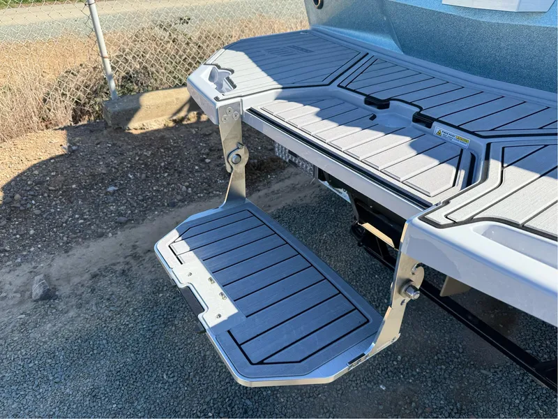 Slide: The Image of 2024 MasterCraft XStar S swim platform with foldable step, shown in outdoor setting. - 37