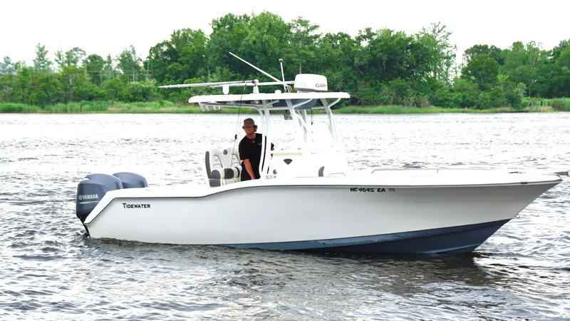 Slide: The Image of 2015 Tidewater 250 CC Adventure boat on water with trees in background. - 1