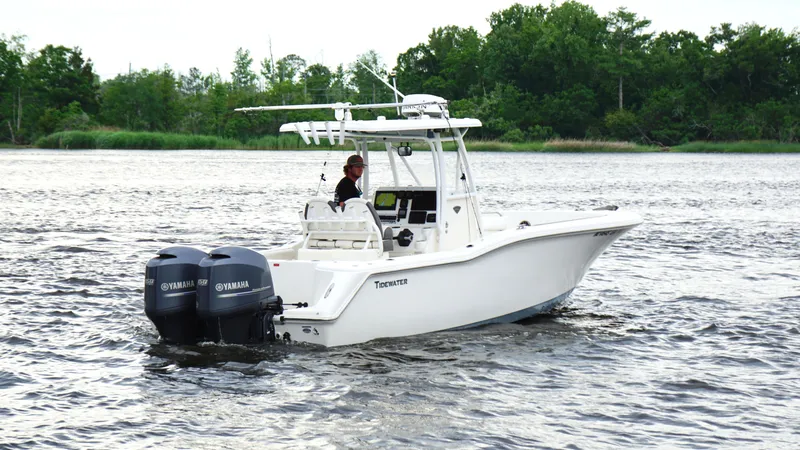 Slide: The Image of 2015 Tidewater 250 CC Adventure boat cruising on a lake with twin Yamaha engines. - 5