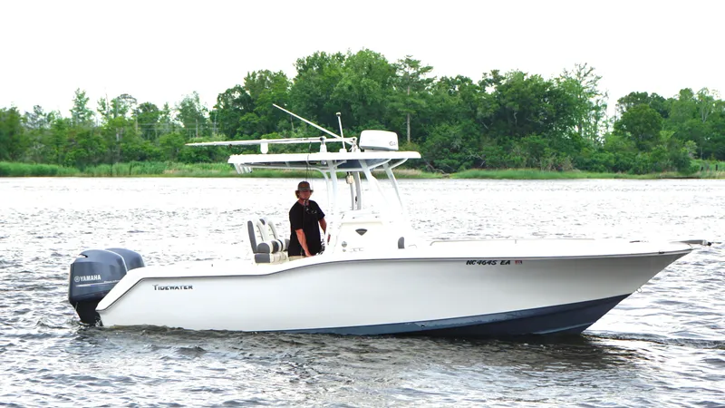 Slide: The Image of 2015 Tidewater 250 CC Adventure boat on water with trees in background. - 6
