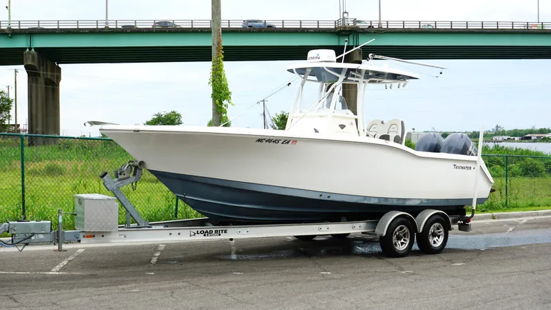 Slide: The Image of 2015 Tidewater 250 CC Adventure boat on trailer, parked near a bridge. - 7