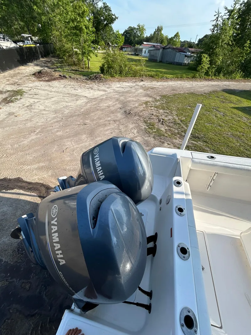 Slide: The Image of 2015 Tidewater 250 CC Adventure boat with dual Yamaha engines, parked on a dirt path. - 9