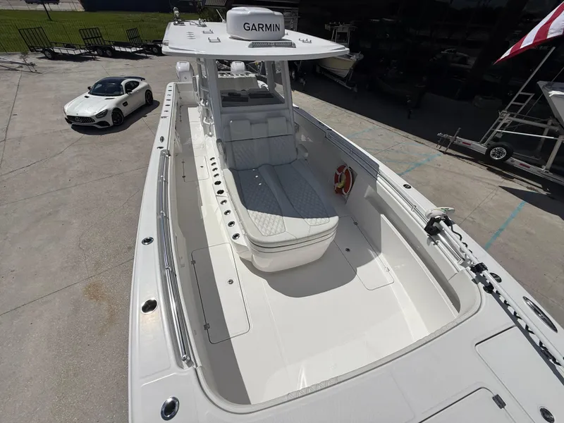 Slide: The Image of 2022 Invincible 33 Catamaran with Garmin equipment, parked near a luxury car. - 12