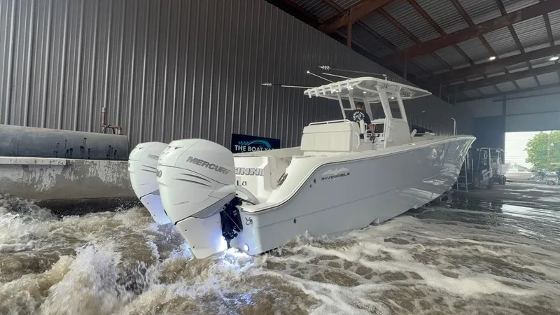 Slide: The Image of 2022 Invincible 33 Catamaran with twin Mercury engines in a boatyard. - 2