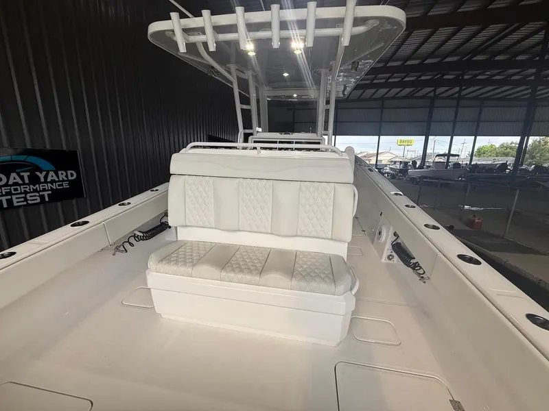 Slide: The Image of 2022 Invincible 33 Catamaran interior with white seating in a boatyard setting. - 22