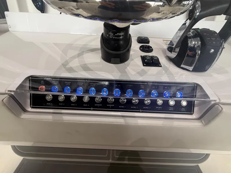 Slide: The Image of Control panel of 2022 Invincible 33 Catamaran with illuminated switches and throttle lever. - 29