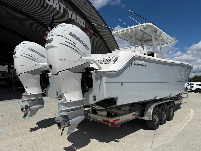 Slide: The Image of 2022 Invincible 33 Catamaran with twin Mercury engines on a trailer at a boat yard. - 3