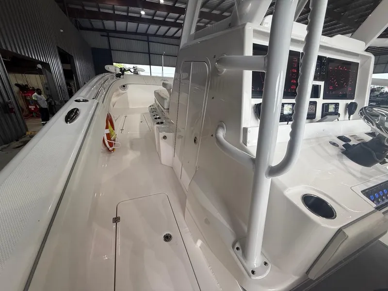 Slide: The Image of 2022 Invincible 33 Catamaran interior with modern controls and spacious deck in a warehouse setting. - 30
