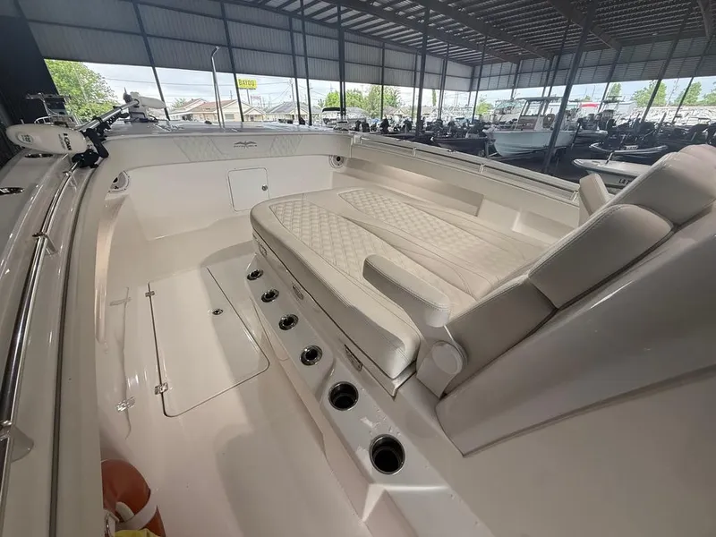 Slide: The Image of 2022 Invincible 33 Catamaran interior with cushioned seating and rod holders in a covered marina. - 31