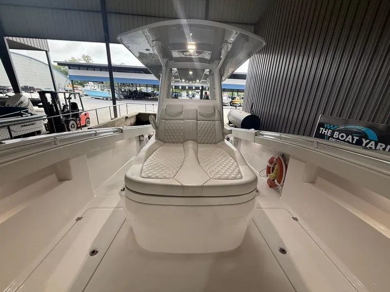 Slide: The Image of 2022 Invincible 33 Catamaran interior with cushioned seating, docked at a marina. - 32