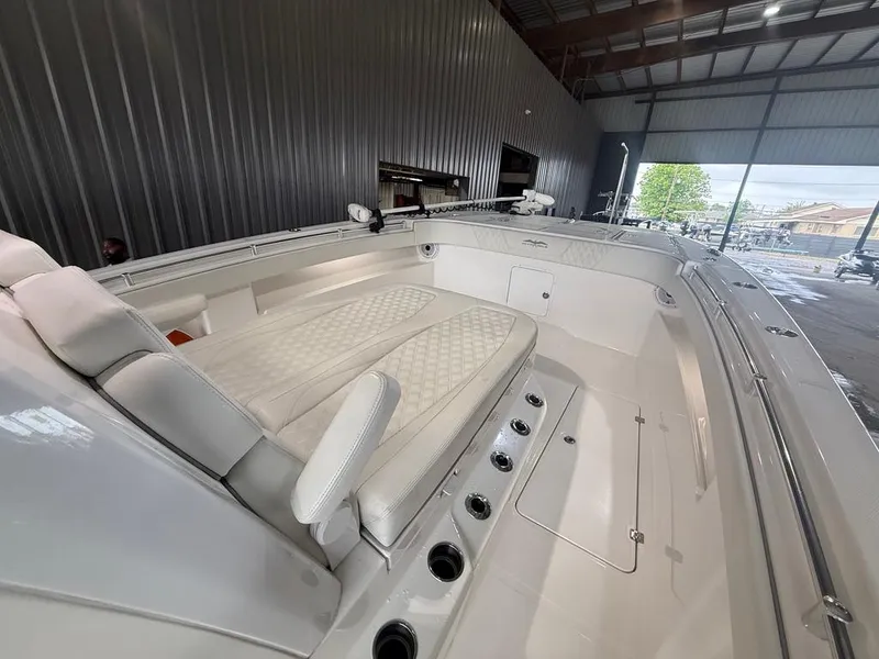 Slide: The Image of 2022 Invincible 33 Catamaran interior with cushioned seating in a spacious boat garage. - 36