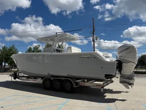 Slide: The Image of 2022 Invincible 33 Catamaran on trailer under blue sky with clouds. - 6