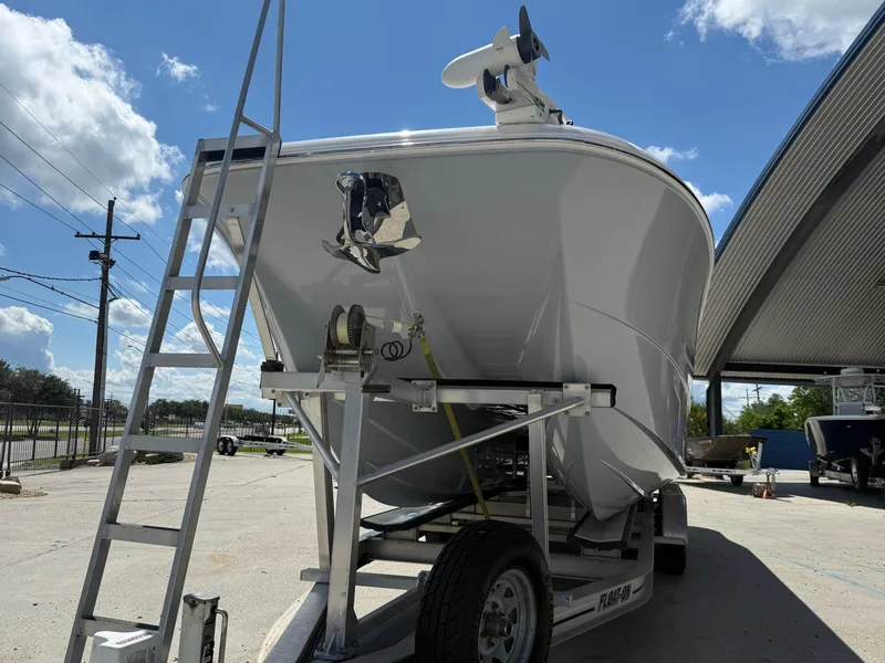 Slide: The Image of 2022 Invincible 33 Catamaran on trailer under clear blue sky. - 8