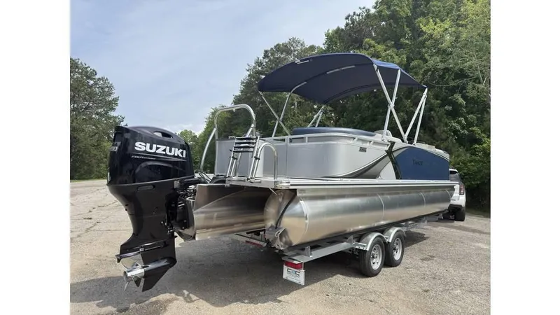 Slide: The Image of 2025 Tahoe LTZ Quad Lounger 23 pontoon boat with Suzuki outboard motor on trailer. - 11