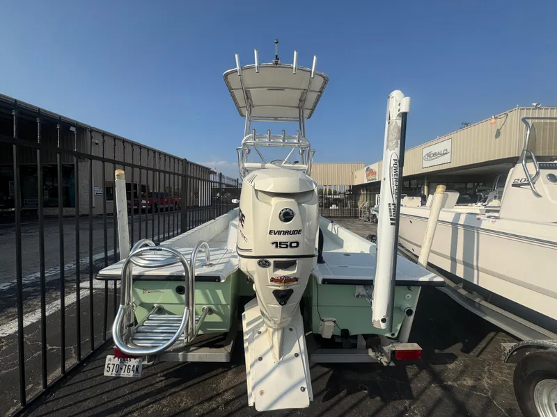 Slide: The Image of 2013 Shallow Sport 21 Sport boat with Evinrude 150 engine, parked outdoors. - 10