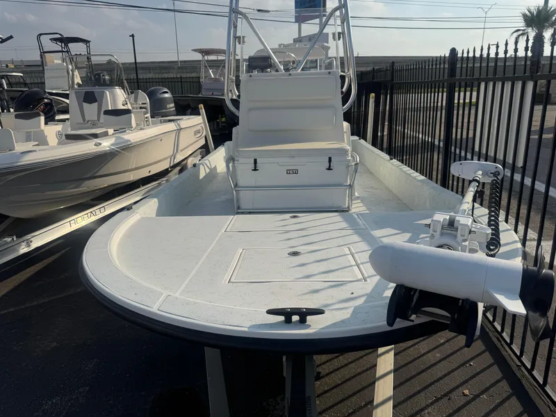 Slide: The Image of 2013 Shallow Sport 21 Sport boat with white deck, parked near other boats. - 3