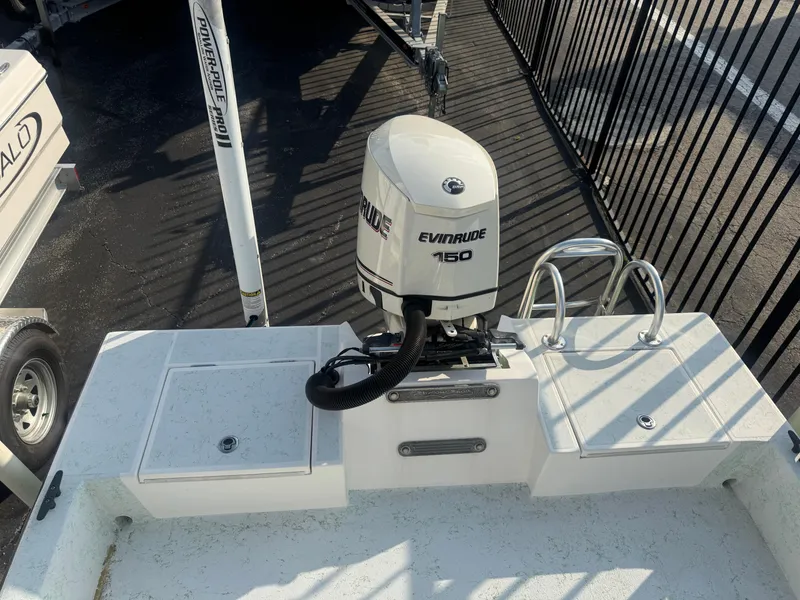 Slide: The Image of 2013 Shallow Sport 21 Sport boat with Evinrude 150 engine, docked near a fence. - 4