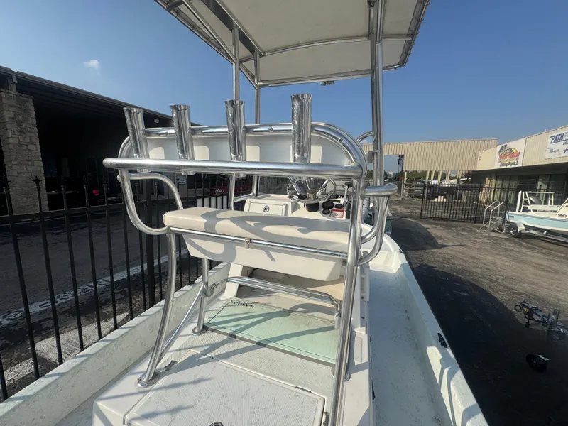 Slide: The Image of 2013 Shallow Sport 21 Sport boat with T-top and rod holders, docked outdoors. - 5