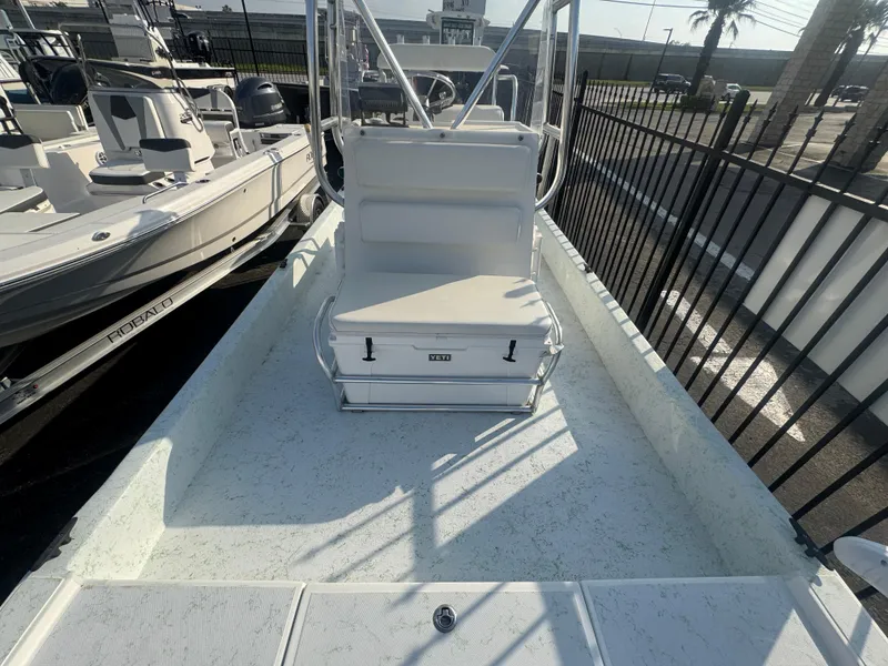 Slide: The Image of 2013 Shallow Sport 21 Sport boat with seating and storage, docked near other vessels. - 9