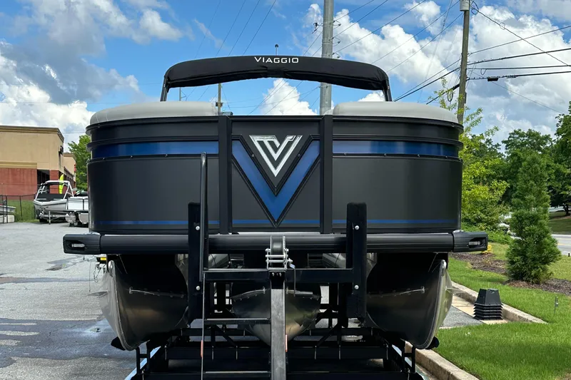 Slide: The Image of 2025 Viaggio Lago X-S pontoon boat on trailer, rear view, under blue sky. - 2