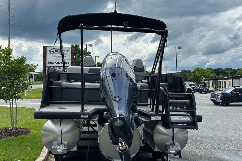 Slide: The Image of 2025 Viaggio Lago X-S pontoon boat with outboard motor, parked outdoors under cloudy sky. - 3