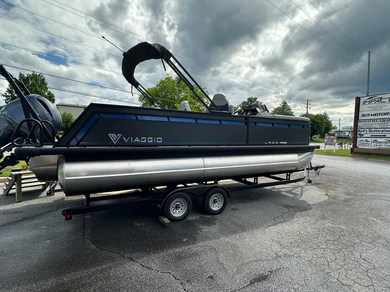 Slide: The Image of 2025 Viaggio Lago X-S pontoon boat on trailer under cloudy sky. - 7